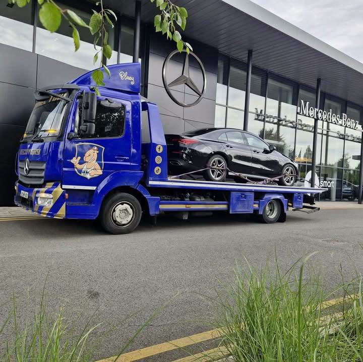 Camel Tow truck “Bluey” delivering a black saloon to a Mercedes-Benz dealership