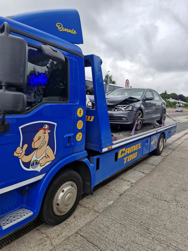 Crash-damaged grey saloon recovered onto Camel Tow truck “Bonnie”, camel logo on the door